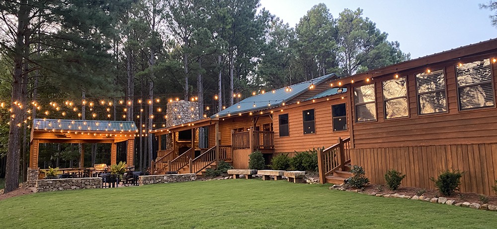 Hurricane Creek Lodge at dusk with string lights over the outdoor pavilion
