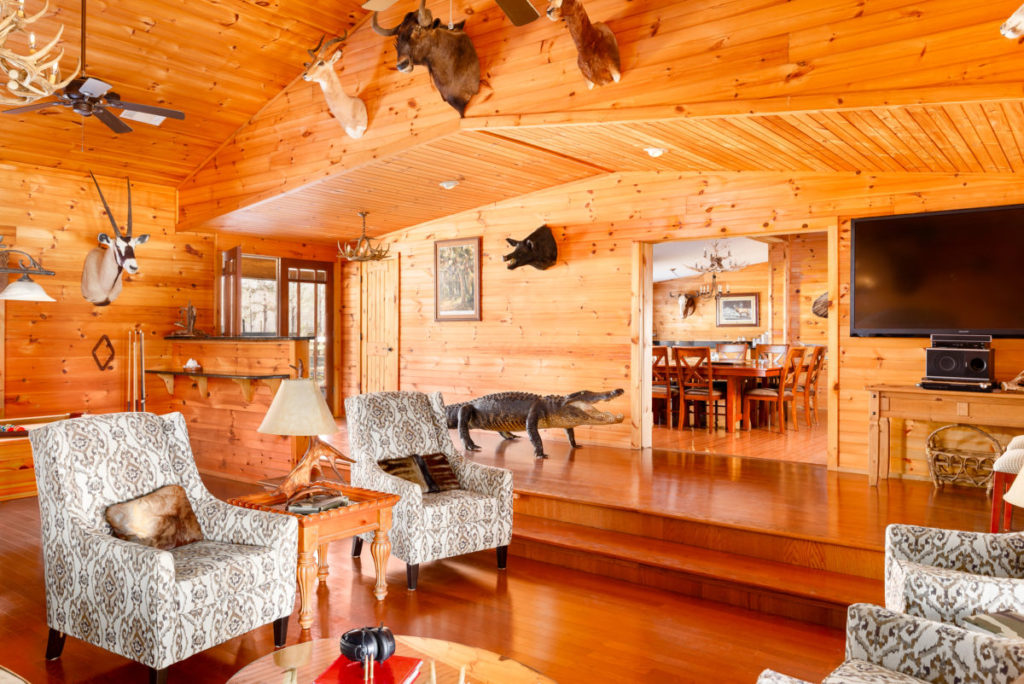 The lodge great room with log walls and mounted trophies