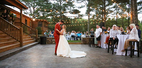Bride and groom's first dance on the outdoor patio under string lights